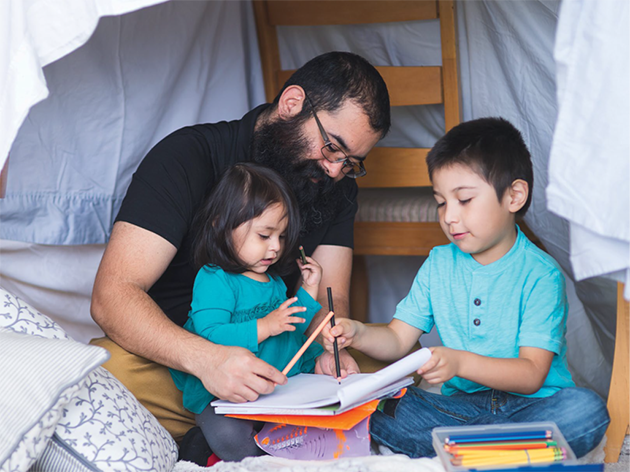 A person and children sitting in a tent