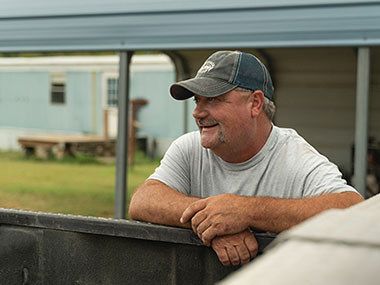 A person leaning on a pickup truck