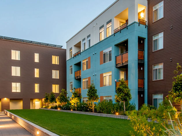 Colorful apartment building complex exterior with a green space courtyard