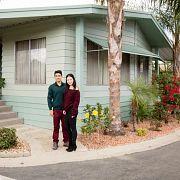 Couple posing for picture near house