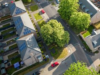 Aerial view of a neighborhood with solar panels on the roofs