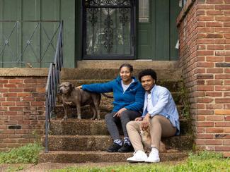 Homeowner and his mother on the front steps of their home with their dog