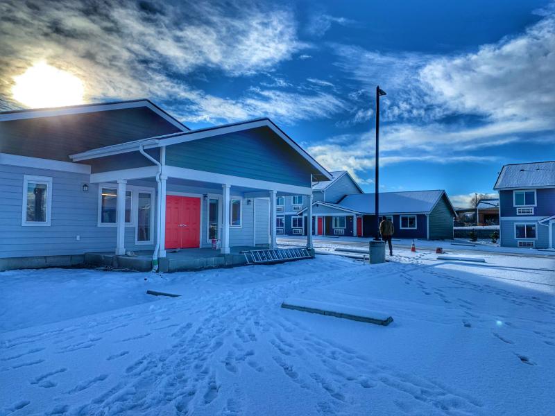 Multifamily housing units with red doors covered in snow