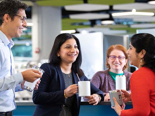 A diverse group of Freddie Mac employees taking a coffee break and conversing