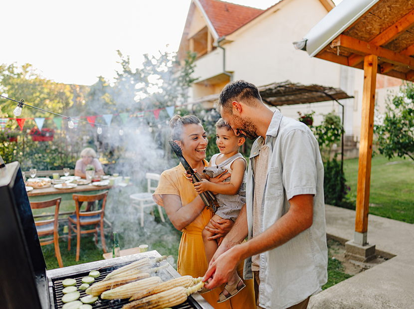Family hosting a summer barbecue in their backyard